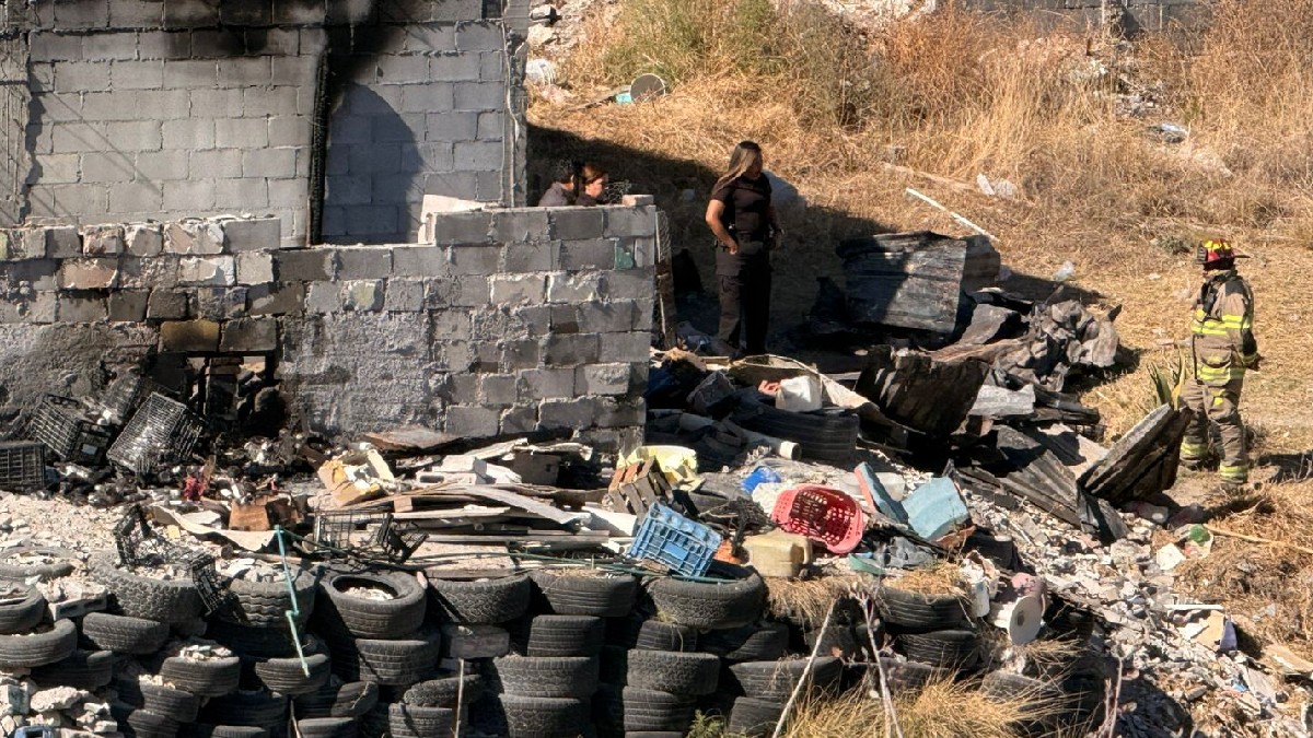 Se observa un terreno con llantas, un bombero unas personas con uniformes de policías.