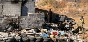 Se observa un terreno con llantas, un bombero unas personas con uniformes de policías.