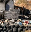 Se observa un terreno con llantas, un bombero unas personas con uniformes de policías.