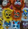 Un grupo de máscaras de diferentes tipos de animales hechas de plástico en un puesto de máscaras de animales