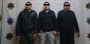 Se observa a tres hombres que visten chamarras negras y pantalones de mezclilla, tienen cubiertos los ojos.