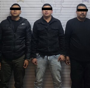 Se observa a tres hombres que visten chamarras negras y pantalones de mezclilla, tienen cubiertos los ojos.