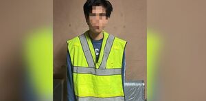 Joven detenido con chaleco verde.