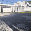 Se observa una fachada de una casa y una cinta amarilla de precaución.