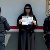 Mujer con los ojos censurados con un recuadro negro y la cara blureada sosteniendo una hoja en medio de dos mujeres elementos de la Policía de Tlaquepaque
