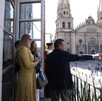 Gobernador de Jalisco, Pablo Lemus Navarro, apuntando con el dedo en un balcón con vista a la Catedral de Guadalajara con mujeres detrás de él