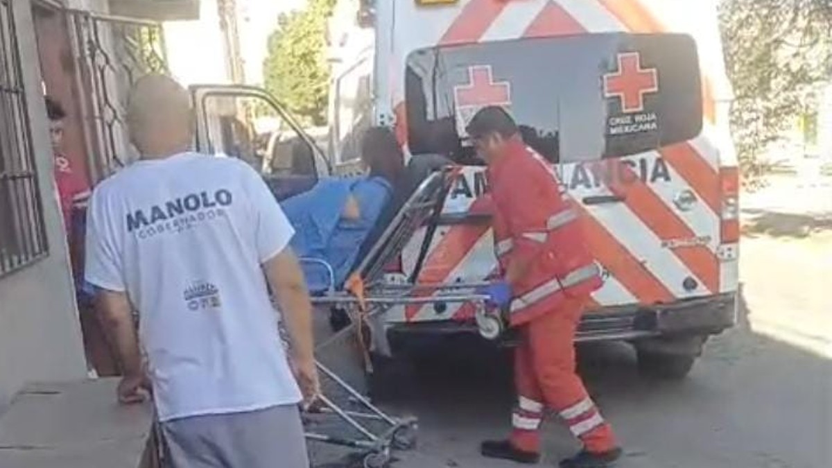 Paramédicos trasladando a un hospital a una mujer que dio a luz a su bebé al interior de su vivienda.