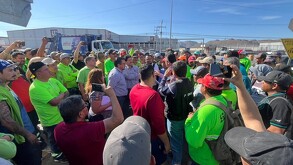 Se observa a muchos hombres con uniforme verde de entre la multitud.