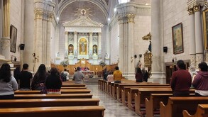 Se observa a varios hombres y mujeres dentro de una iglesia.