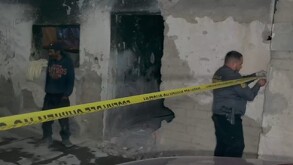 Se observa a dos hombres, es en la noche, hay una cinta amarilla de precaución.