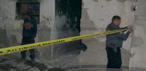 Se observa a dos hombres, es en la noche, hay una cinta amarilla de precaución.