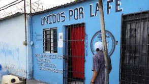 Hombre parado afuera de un anexo llamado 