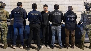 Dilan Kaled N con la cara censurada con recuadros, parado en medio de oficiales de la Fiscalía de Michoacán, Guardia Civil y militares de la Marina