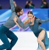 Pareja de competidores de patinaje artístico durante una competencia en Milano-Cortina 2026.