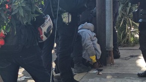 policías y personas rodean a un hombre acusado de ser asaltante