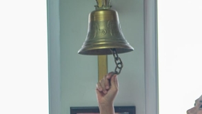 Mano de mujer toca una campana de victoria al vencer el cáncer.