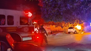 Carro prendido en llamas y elementos de Bomberos atendiendo el siniestro.