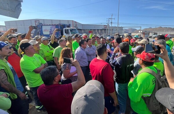 Se observa a muchos hombres con uniforme verde de entre la multitud.