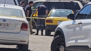 Patrulla de la Policía de Tlajomulco con autos, oficiales y militares detrás de un área acordonada por una cinta policiaca amarilla