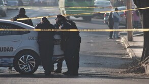 Policías recargados sobre una patrulla de la Policía Municipal en Puebla.