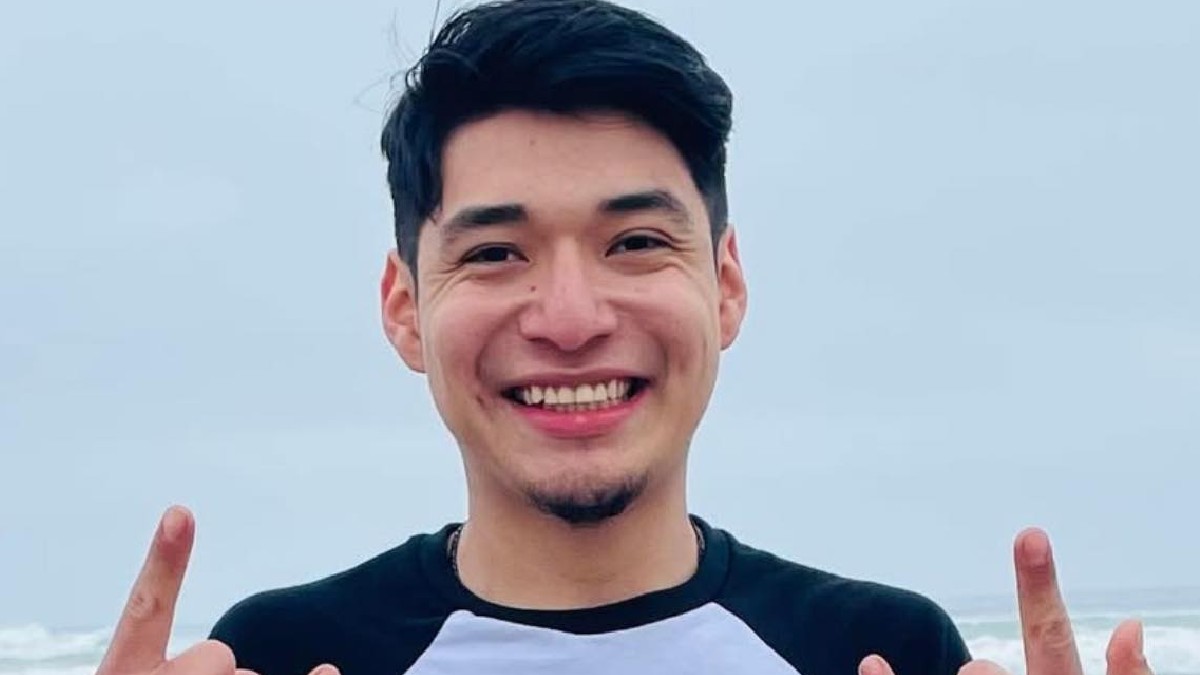 Joven sonriendo con playera blanca y negra