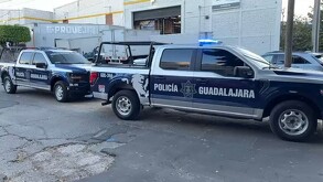 Dos patrullas de la Policía Municipal de Guadalajara estacionadas al exterior de una empresa de traslado de valores y cajas fuertes