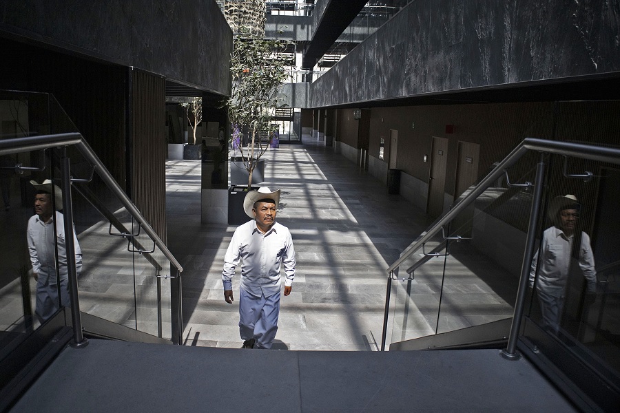 Hombre con sombrero sosteniendo unos libros.