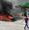 Automóvil envuelto en llamas frente a una gasolinera de Pemex con un hombre caminando a un lado
