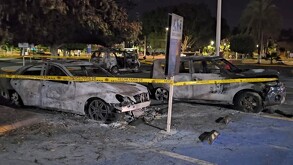Tres vehículos calcinados en un estacionamiento para discapacitados acordonado por una cinta policiaca amarilla