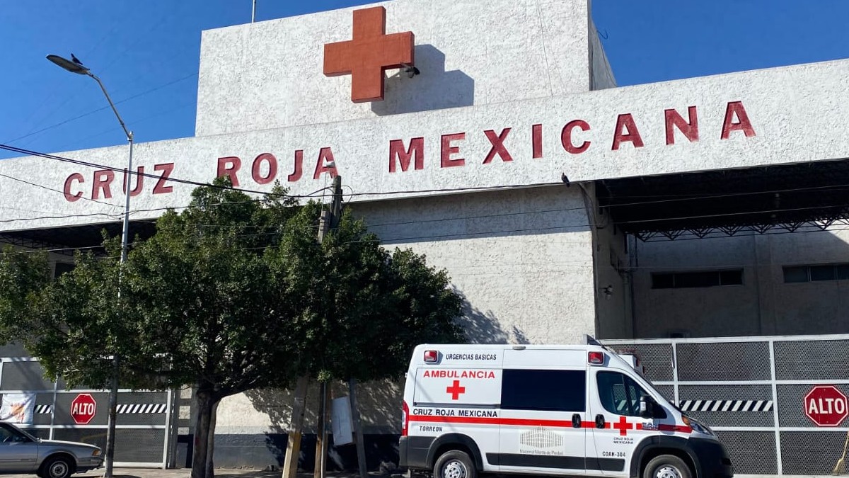 Ambulancia de Cruz Roja y fachada de institución en color blanco