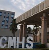 Se observa una fachada color gris con morado, unas letras de CMSH.