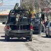 Se observan a varios hombres vestidos de militares, algunos arriba de camionetas.