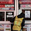 un hombre se asoma a la puerta de una tienda oxxo en puebla