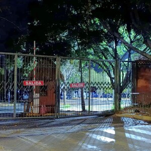Vista del exterior del Zoológico de Guadalajara con las rejas cerradas con carteles de salida durante la noche-madrugada