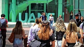 Se observa a varios jóvenes con mochilas, y unas letras al fondo que dicen UANE.