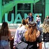 Se observa a varios jóvenes con mochilas, y unas letras al fondo que dicen UANE.