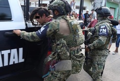Hombre siendo detenido por elementos del Ejército Mexicano y llevado a una patrulla policial.