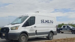 Camioneta blanca de SEMEFO junto a patrulla de Policía