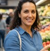 Mujer haciendo compras en el supermercado eligiendo limones y sonriendo