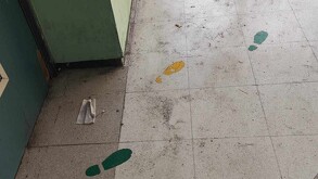 Se observa un piso sucio, hay unas huellas pintadas en el suelo.