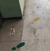 Se observa un piso sucio, hay unas huellas pintadas en el suelo.