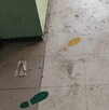 Se observa un piso sucio, hay unas huellas pintadas en el suelo.