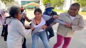 Personas reteniendo a una mujer en la Cámara de Diputados de Oaxaca.