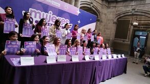 mujeres sostienen carteles de actividades por el 8 de marzo en puebla