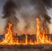 Se observa un terreno baldío con llamas de fuego.