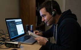 Hombre en unca computadora con diadema de micrófono y audio