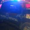 Vista del costado de una patrulla de la Policía del Estado de Jalisco con la sirena encendida durante la noche