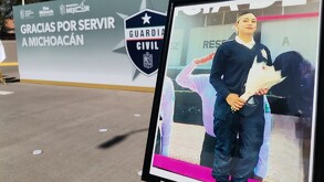 Fotografía de la oficial Karla Lorena Patiño Gutiérrez sosteniendo un ramo de flores al lado de un cartel de la Guardia Civil de Michoacán