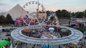 Aspecto de la Feria de Puebla, con juegos mecánicos y personas asistentes.