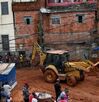 Bomberos y trabajadores de defensa civil ayudan en el lugar donde se derrumbaron casas.